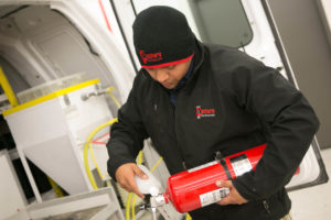 Employee recharging a fire extinguisher